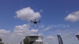Drone delivers a package to a roof-top box, then a man picks-up his package