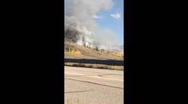 Forest Fire in Colorado behind a highway in Summit County, emergency vehicles activated