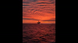 North Sea oil rig captured in front of stunning orange sky before a storm