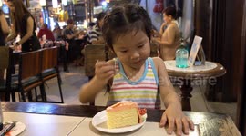 Young Thai girl at a birthday party demolishes her cake then wants mine