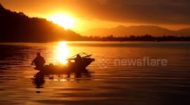 Beautiful sunset scene with man on boat in Dal Lake, Jammu and Kashmir