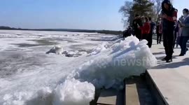 Tourists take pictures as huge chunks of ice wash up on river in northern China