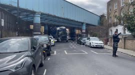 Newsflare Edit - Truck removed after becoming lodged underneath railway bridge in Camden, London