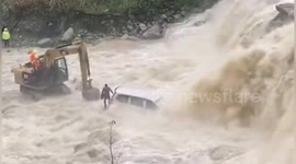 Chinese police use excavator to rescue motorist from minibus trapped in flooded river