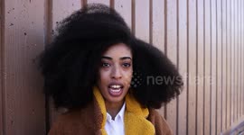 A woman who stopped having her hair straightened to save money has grown one of the world's largest AFROS - which stands at a whopping 4ft 10in