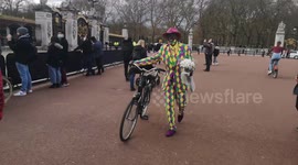 Man in colourful suit pays tribute to Prince Philip with flowers at gates of Buckingham Palace