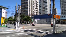 Brazilian street performer juggling on a slackline while cars wait at the lights