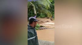 Swollen river submerges bridge and traps residents after a heavy flash flood hit the Philippines