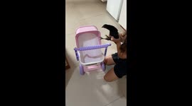 The girl is taken the chicken, instead of dolls, for a stroll.