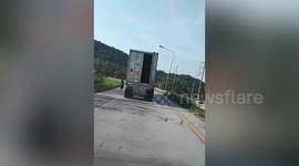 Truck dangerously travels on road with rear door swinging open