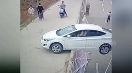 Car dangles several metres off raised curb after driver reverses through guardrails in China