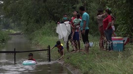 Barber gives bizarre hair cuts in the middle of canal in Thailand