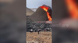 Volleyball players have a game in front of an erupting volcano