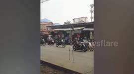 Monkey balances on top of two bamboo stilts attached to its legs while walking