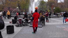 Soccer player entrances onlookers while dancing to rock band with ball balanced on his head
