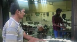 Workers at this food stall toss dough to each other as they cook their goods