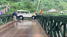 Car makes painfully slow turn after getting stuck sideways on bridge in India