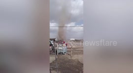 Chinese man calmly uses water hose to 'wash away' dust devil