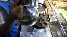 Thai baker shows process of making cannabis cakes on his street food stand