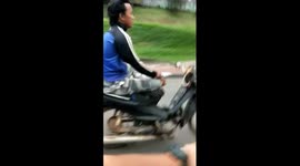 Indonesian motor scooter rider performs dangerous stunts at high speed on public road