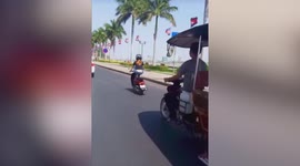 Motorcycle rider dances like ballerina while riding in Caambodia