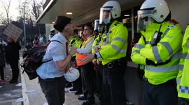 Person dressed as Kroneke attempts to give fake money to police at Kroneke Out Protest