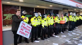 Arsenal fan poses with riot police officer at Kroneke Out protest