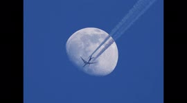 Jet crosses centre of waxing gibbous moon in Sheerness, Kent, UK