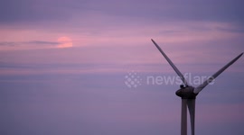 Pink Full Super Moon rising over wind turbines at Longcliffe Quarry, Ryder Point Derbyshire Dales UK