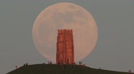 Glorious pink supermoon rises behind Glastonbury Tor in UK