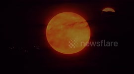 Full pink supermoon rising through clouds in Minster on Sea, Kent, UK