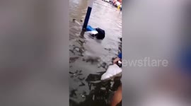 Chinese pedestrians rescue pupil after he gets an electric shock and falls into floodwater