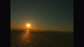 A pink supermoon rises over the ice of Lake Baikal. Eastern Siberia, Russia