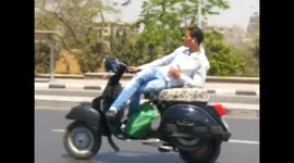 Motor scooter rider lies down on busy road
