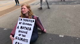 Extinction Rebellion protester weeps whilst she blocks off a road in Piccadilly Circus
