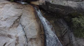 Drone view of a waterfall with a lot of water and river and a lot of trees in a sunny day