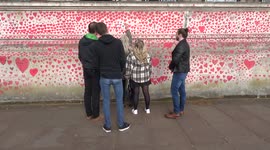 Visitors drawing hearts on the National COVID Memorial Wall in London