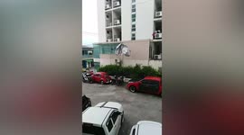 Car cover tossed around by strong winds during storm in Thailand