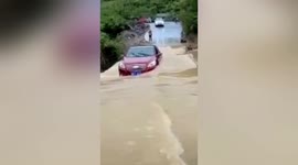 Chinese motorists rescued before their vehicle is swept off bridge by rapid floodwater