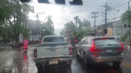 Summer storms pull down electricity posts on flooded roads in northern Thailand