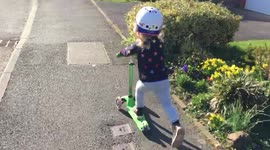 Two-year-old girl going fast on her scooter