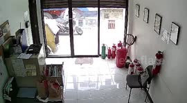 Quick-thinking shop manager rushes outside to control burning motorcycle