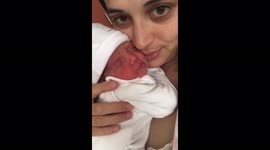 Newborn baby with his mother. The first cuddles together, while the other twin is in the Nicu