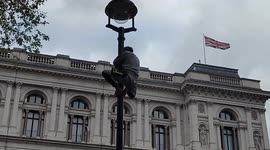 Man climbs lamp post at Whitehall waving Palestinian flag