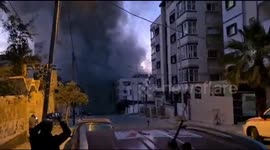 Gaza residents film as building at end of street is struck by rocket