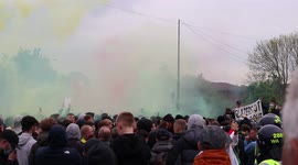 Manchester United fans throw bottles at the police. As they chant & set off flares. At the Glazers out protest outside Old Trafford