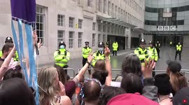 Large group of protesters outside the BBC building, singing
