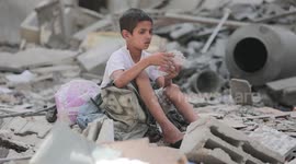 Palestinian boy picks out playing cards from rubble left by Israeli airstrikes