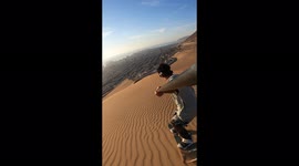 Sandboarder films as he glides down dunes in Chilean desert