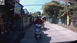 Bungling motorbike rider loses control and hits rear bumper of car in front
